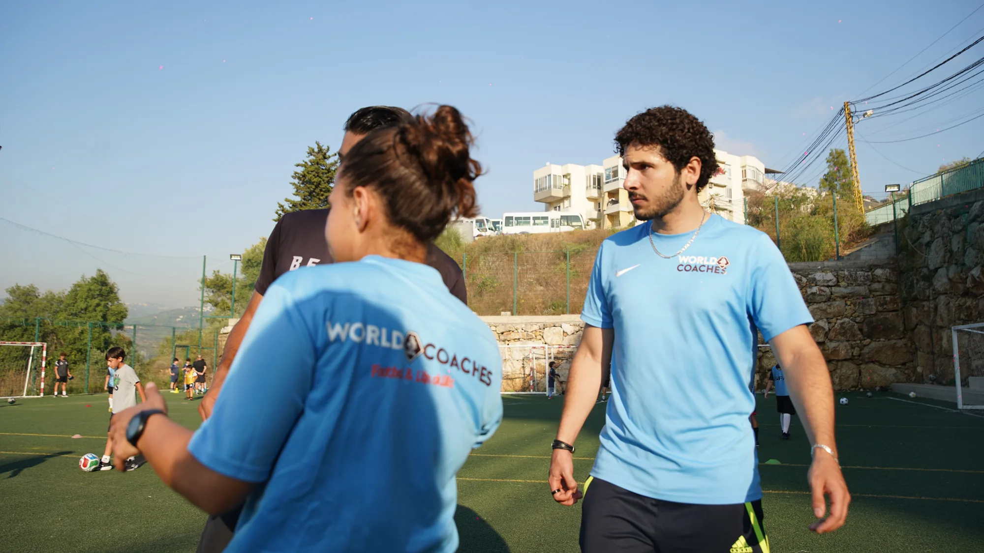 Coaches in WorldCoaches kit talking through a session plan