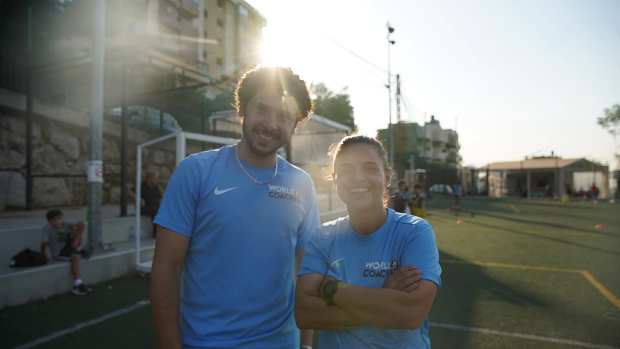 Two coaches at golden hour on the pitch